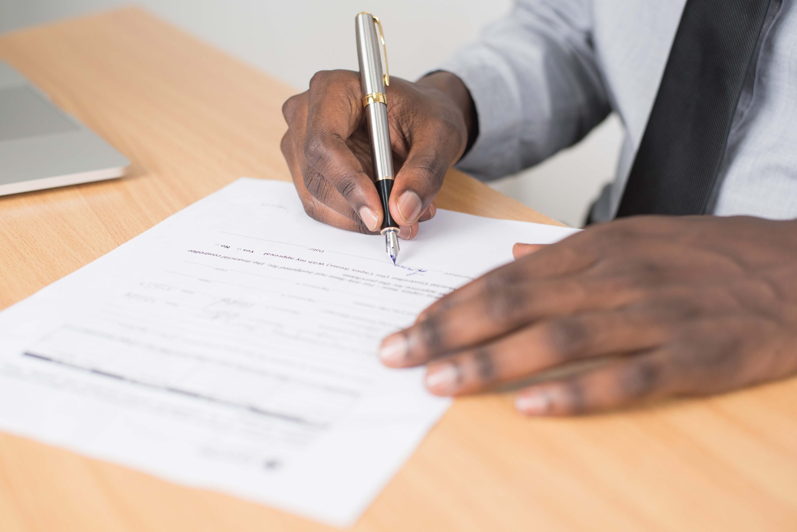 Personne écrivant sur du papier blanc avec un stylo