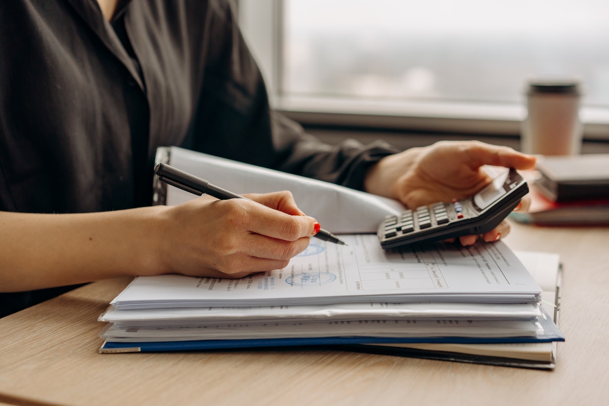 Femme calculant mensualités prêt immobilier avec calculatrice