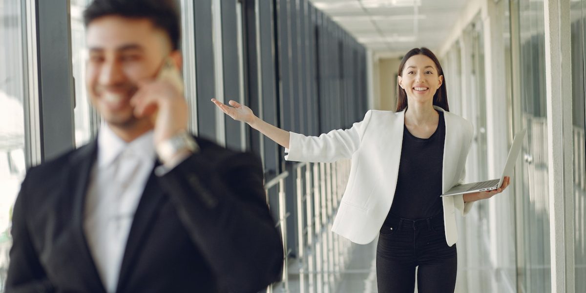 Femme d'affaires joyeuse suivant un homme en costume