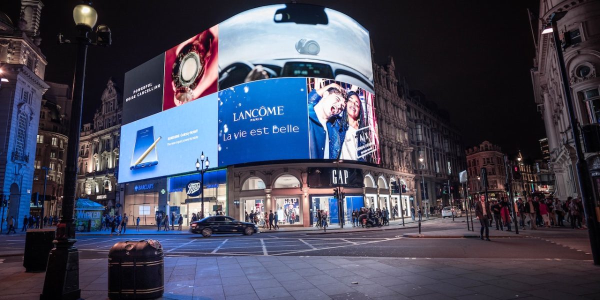 Ville nocturne avec affichage publicitaire et piétons