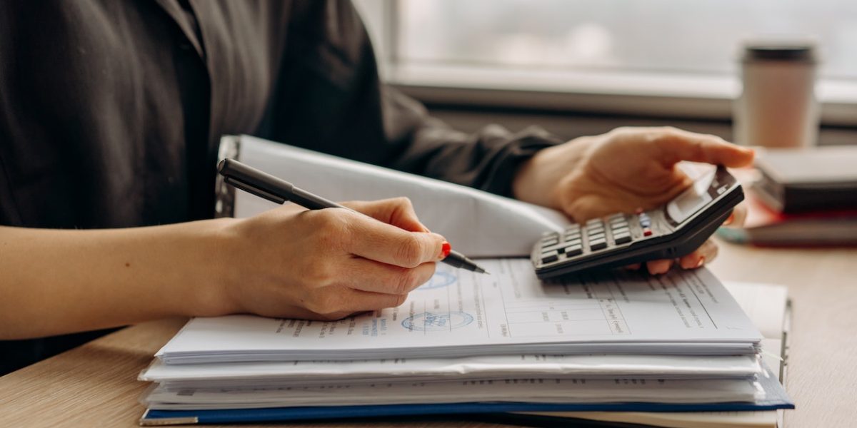 Femme calculant mensualités prêt immobilier avec calculatrice